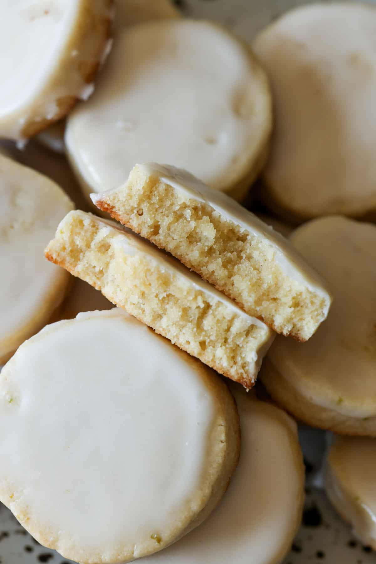 Lime shortbread cookies broken in half stacked on a plate