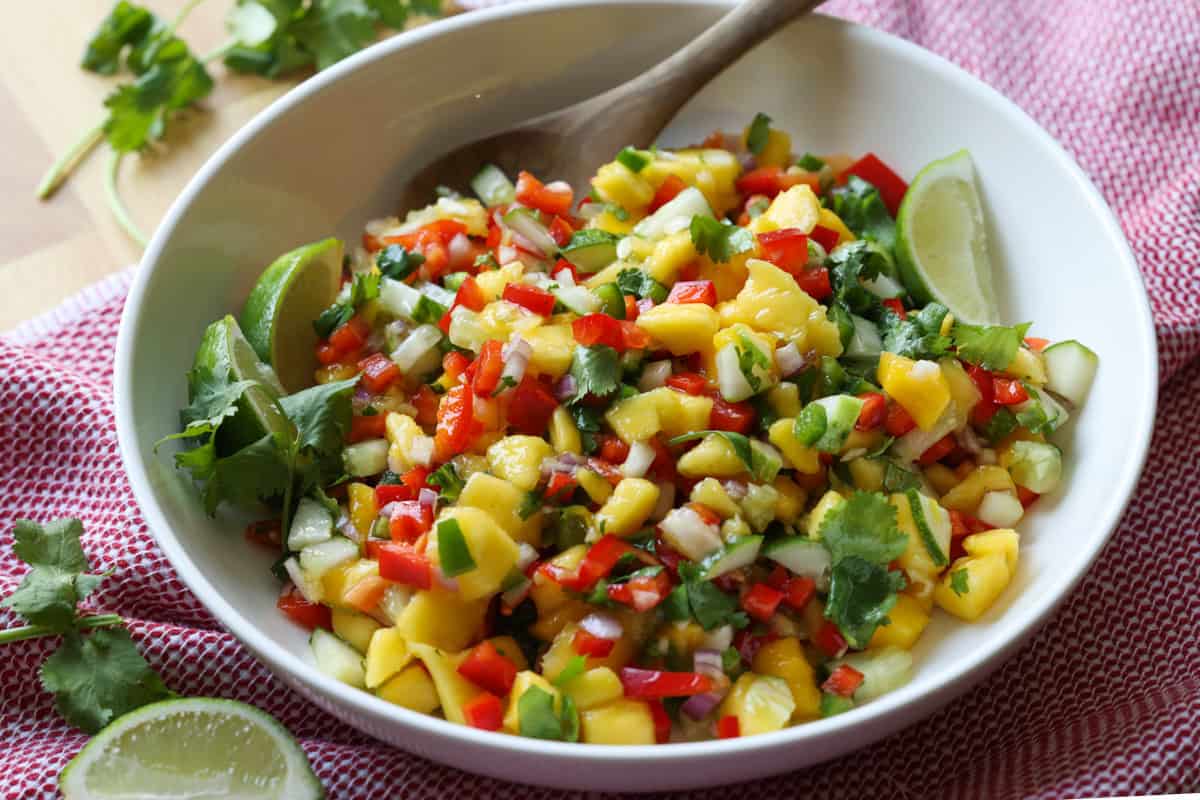 Fruit Salsa in a white bowl with a wooden spoon