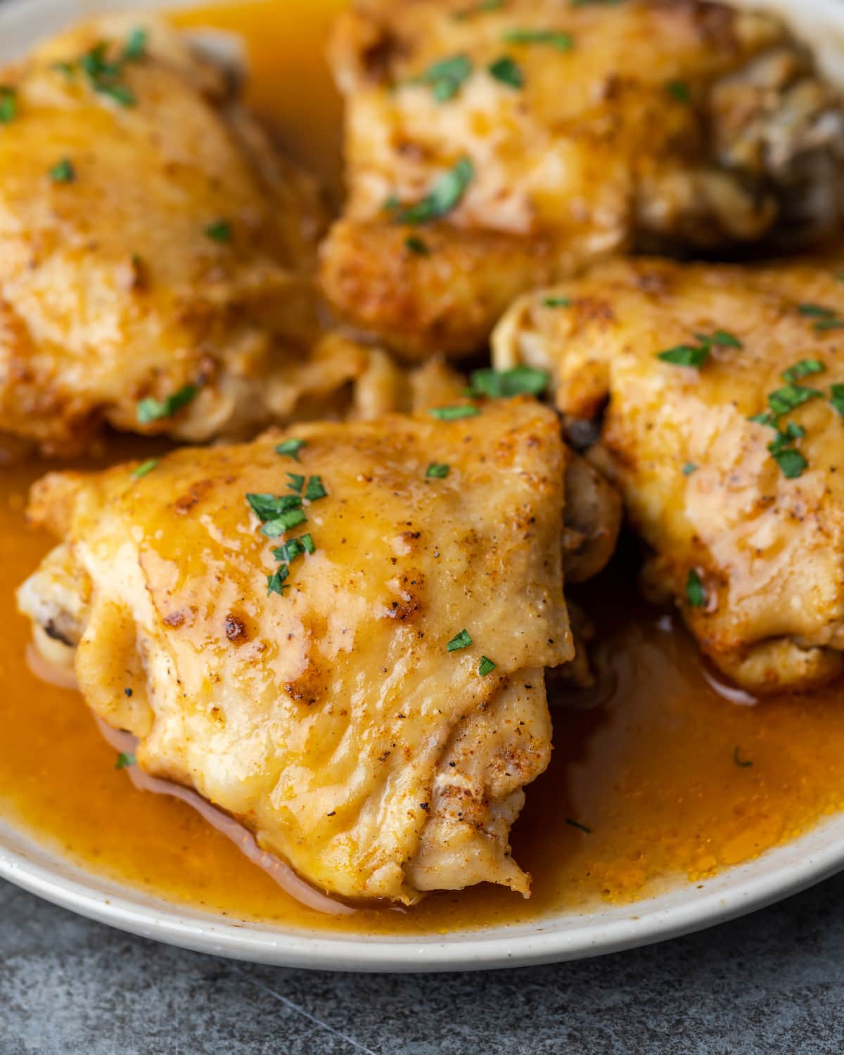 Close up of instant pot chicken thighs on a plate smothered with gravy.