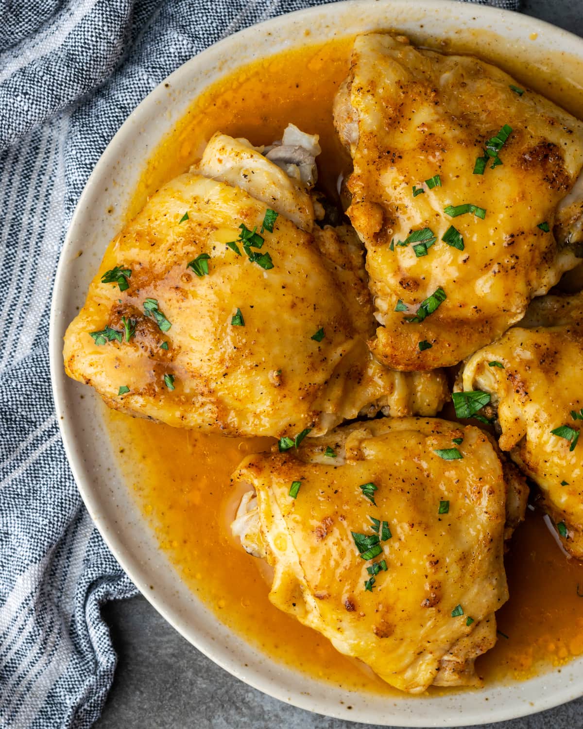 Top view of instant pot chicken thighs on a plate smothered with gravy.