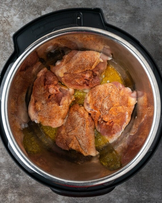 Top view of raw chicken thighs in the bowl of the instant pot.