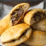 Philly cheesesteak stuffed biscuits in a pile on a plate.