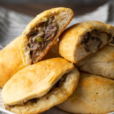 Philly cheesesteak stuffed biscuits in a pile on a plate.