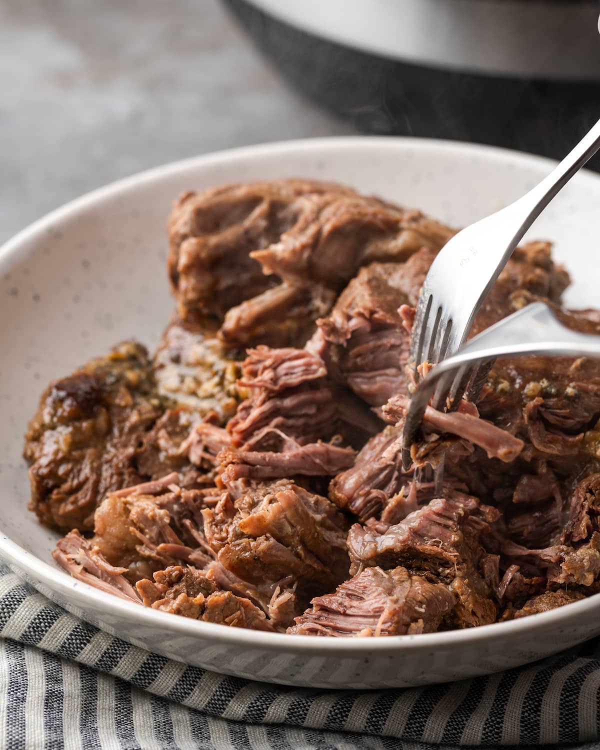 A fork is used to pull the cooked beef apart for Mississippi pot roast.