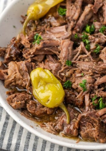 Close up top view of Instant Pot Mississippi pot roast on a serving platter topped with pepperoncini.