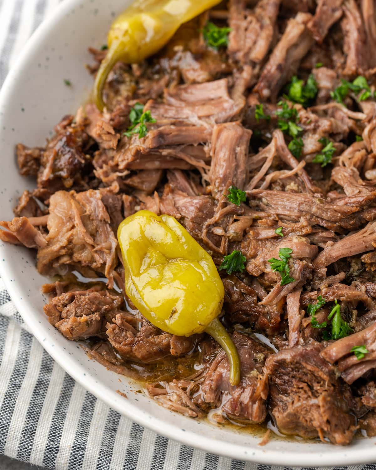 Close up top view of Instant Pot Mississippi pot roast on a serving platter topped with pepperoncini.