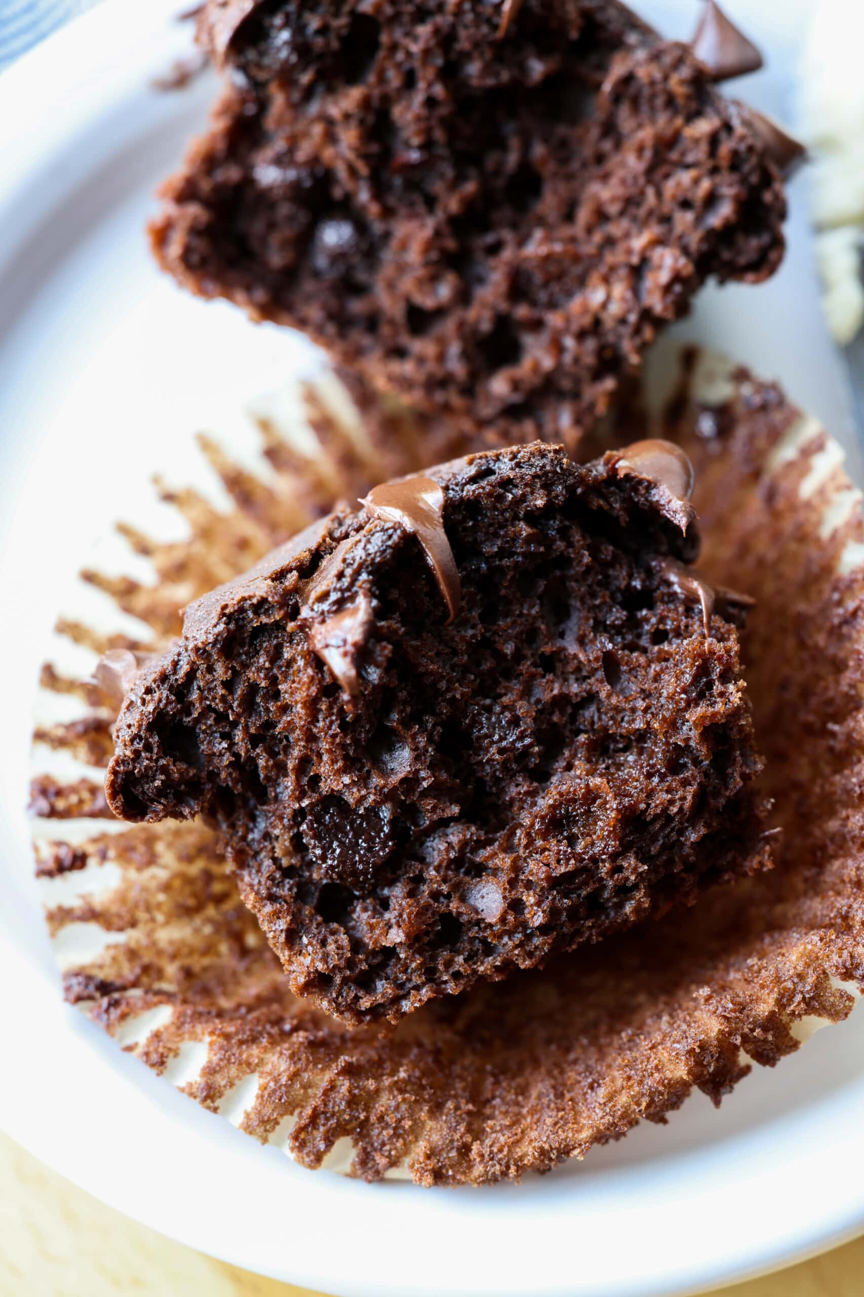 chocolate muffin cut in half on a cupcake liner