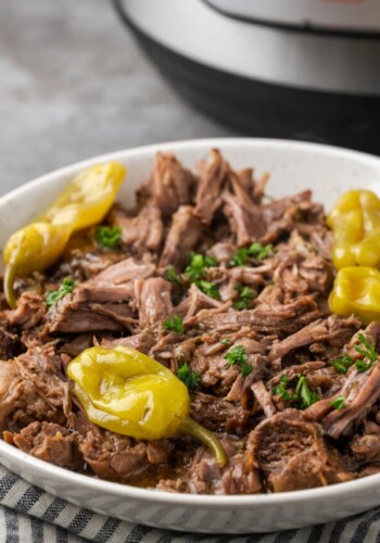 Instant Pot Mississippi pot roast on a serving platter topped with pepperoncini.