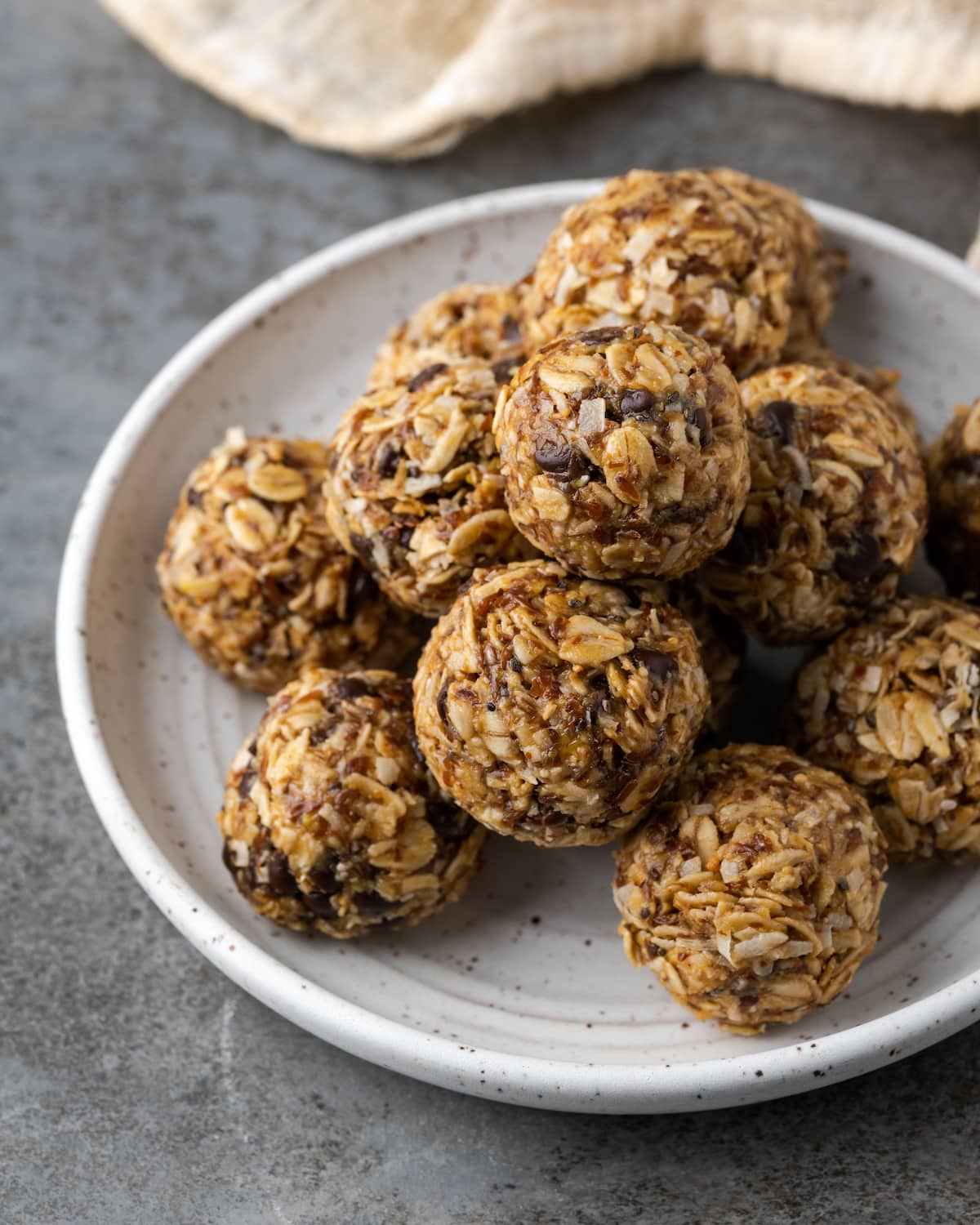 No-bake energy bites stacked on a white plate.