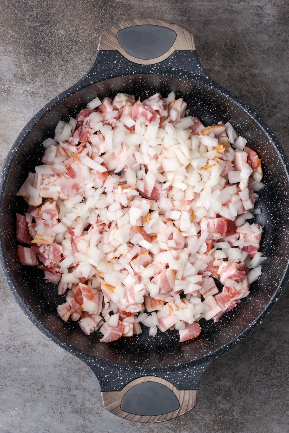 Diced onion and bacon in a large cast iron skillet.