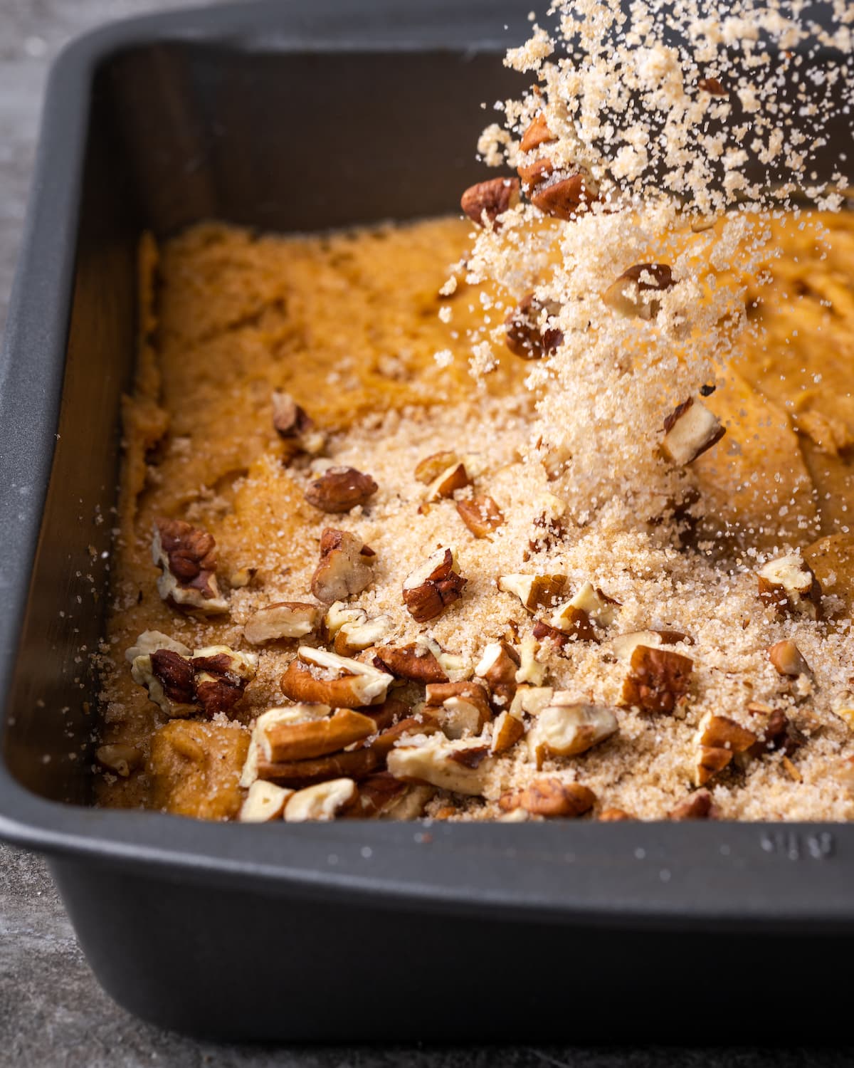 A sugar and pecan mixture is poured over top of the cake layer for pumpkin cobbler.