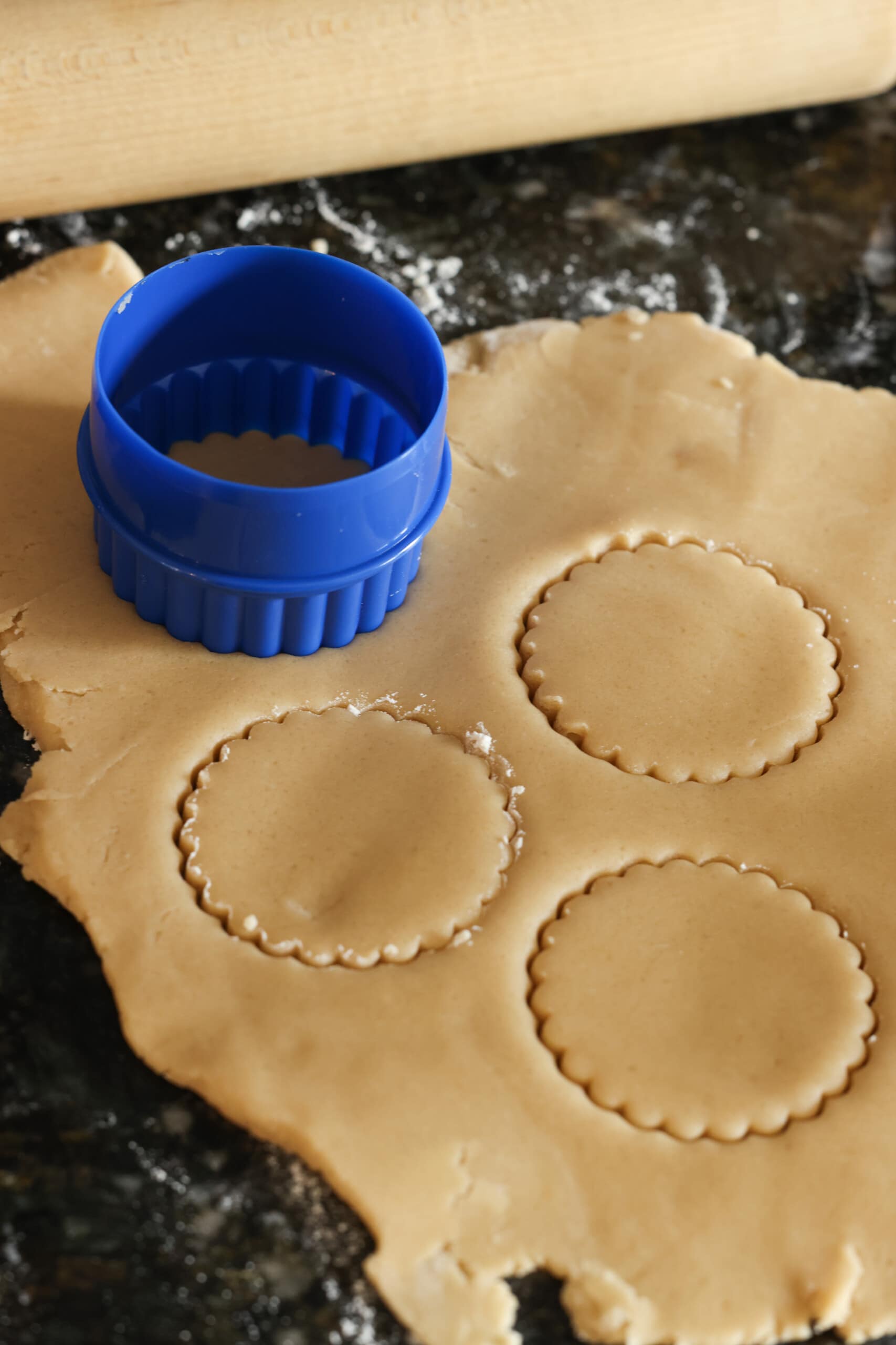 Cortar la masa de galletas de azúcar moreno con el cortador de galletas.