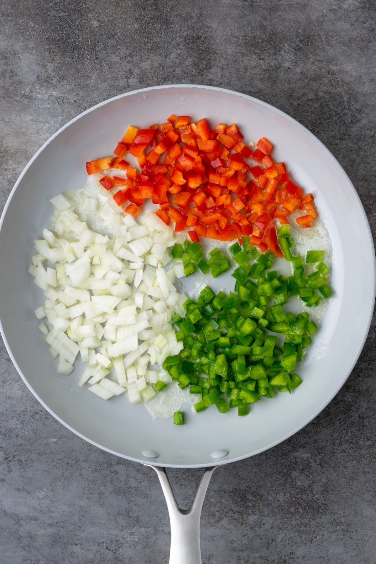 Diced onions and peppers in a skillet