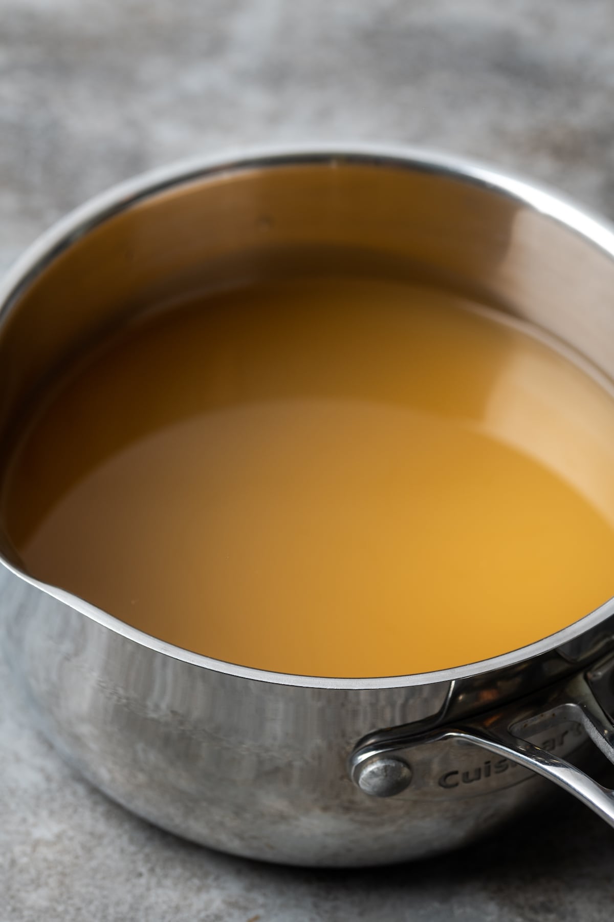 Chicken broth in a metal pot.