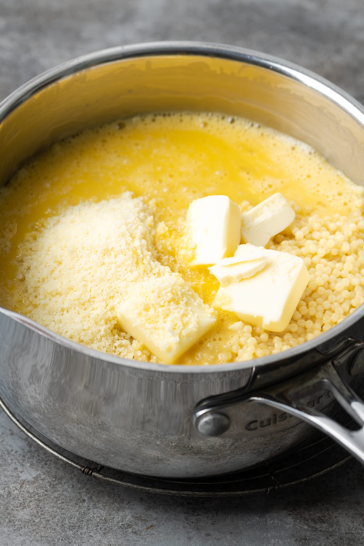 Butter, parmesan cheese, and egg added to a pot of pastina pasta.