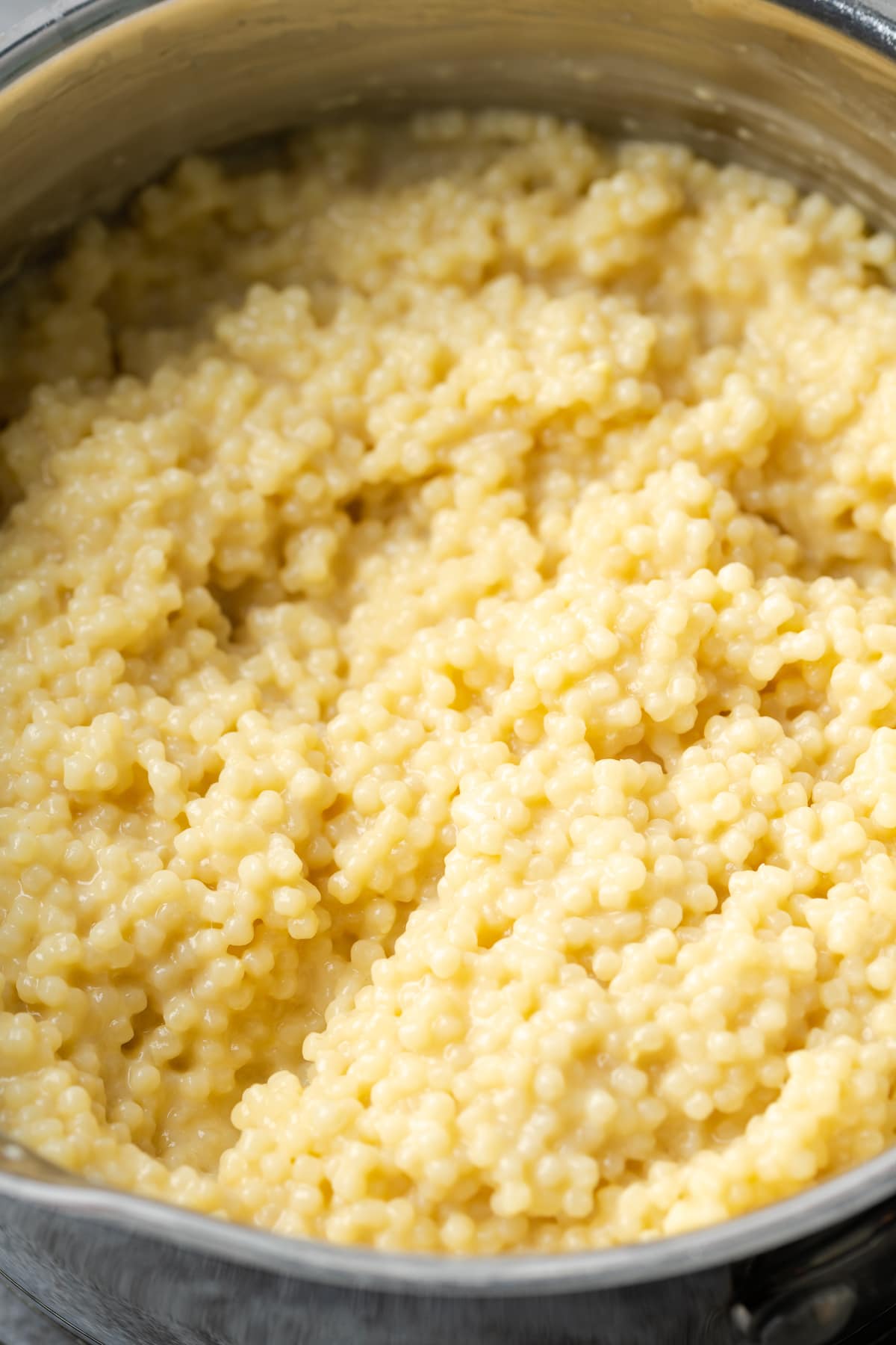 Close up of creamy pastina pasta inside a pot.