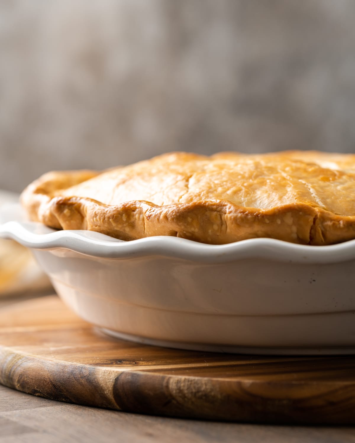 Side view of a baked chicken pot pie in a pie plate.