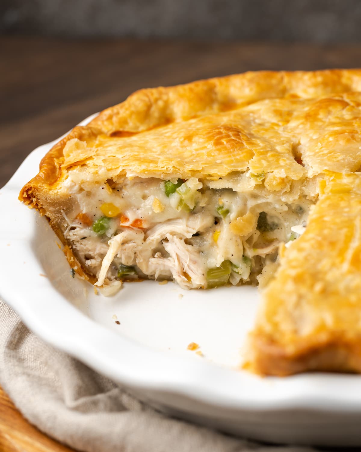 Chicken pot pie in a pie plate with a slice missing.