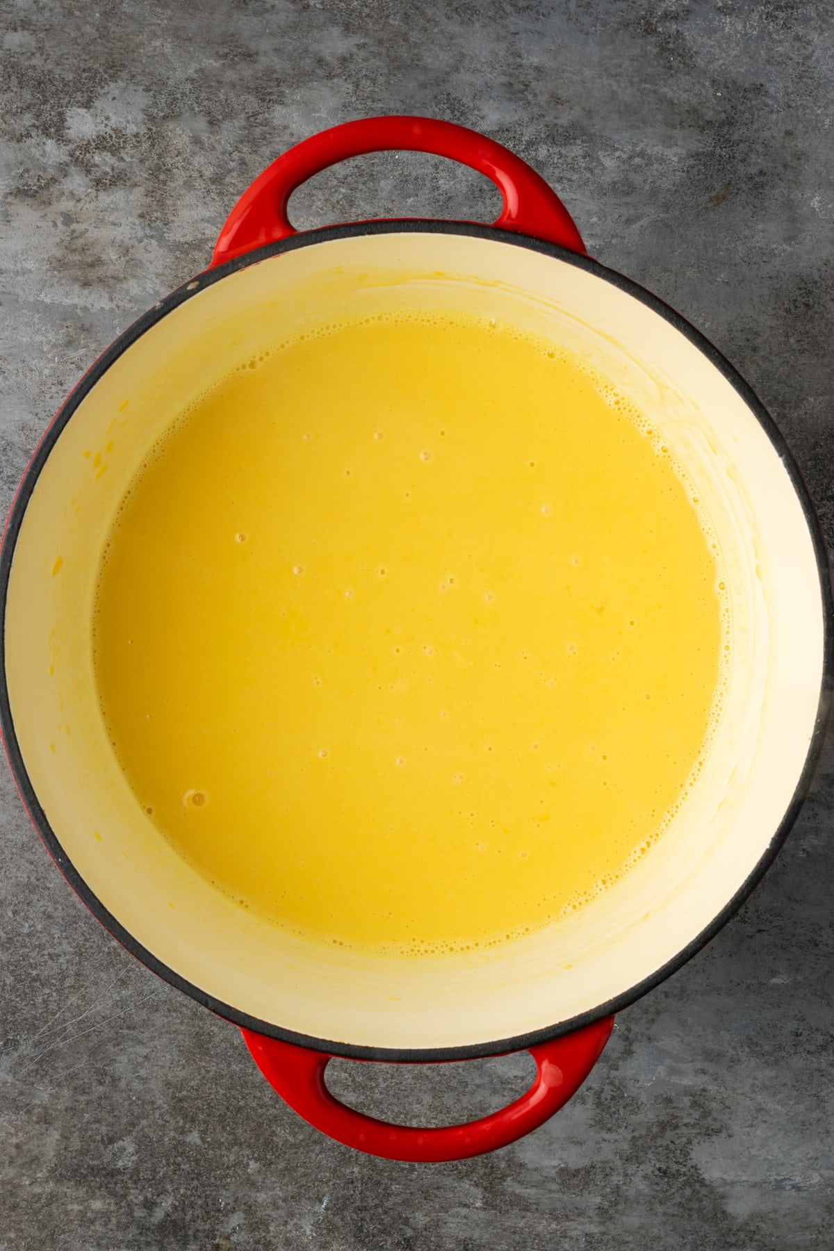 Melting cheese sauce with mac and cheese in a large pot.