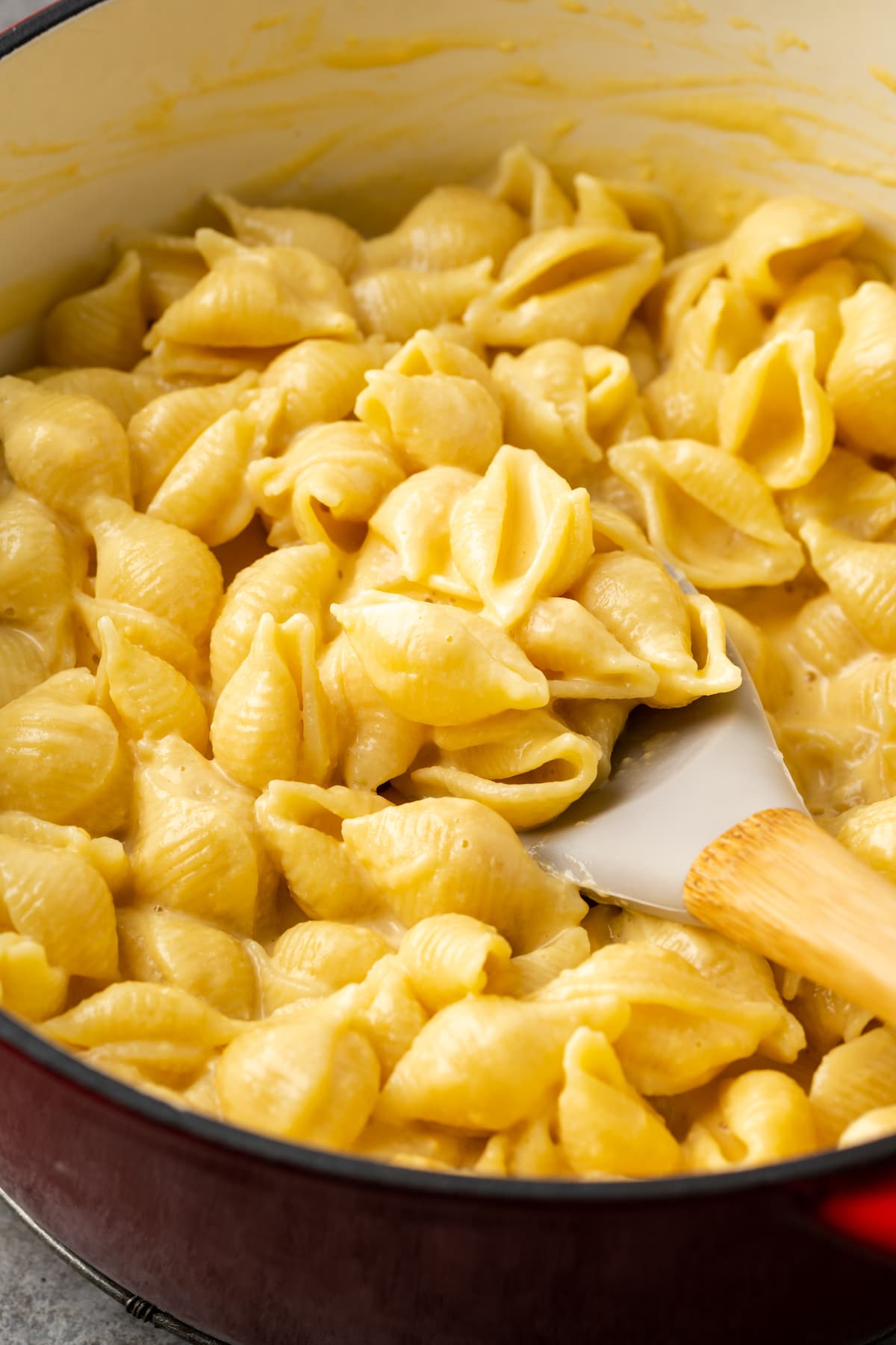 Stovetop mac and cheese in a large pot with a stirring spoon.