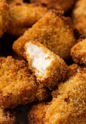 Close up of air fryer popcorn chicken with a bite missing from a nugget.