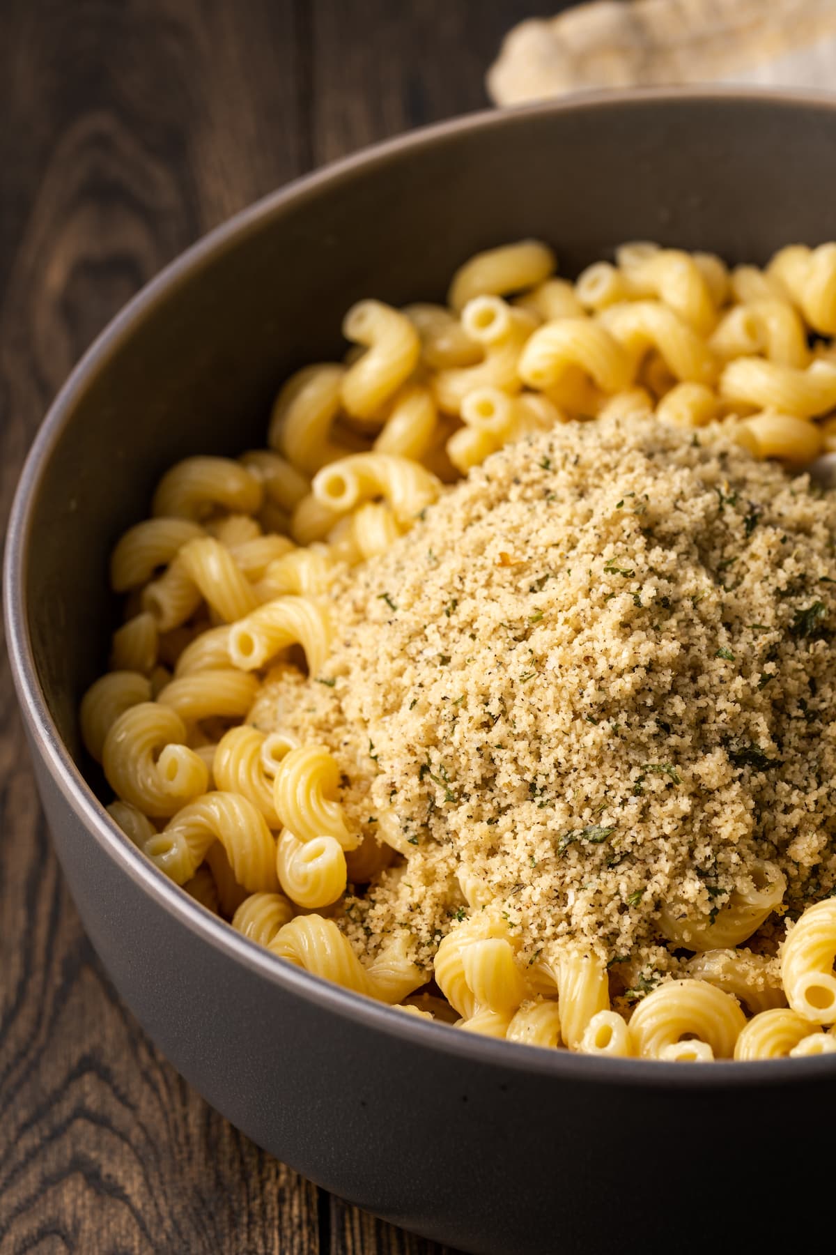 Seasoned breadcrumbs added to a pot of garlic butter pasta.