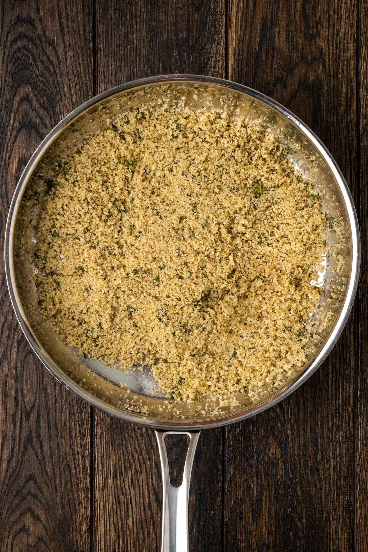 Breadcrumbs toasting in a skillet with butter and seasonings.