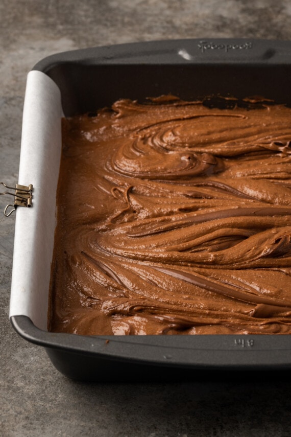 Nutella swirled brownie dough in a baking pan.