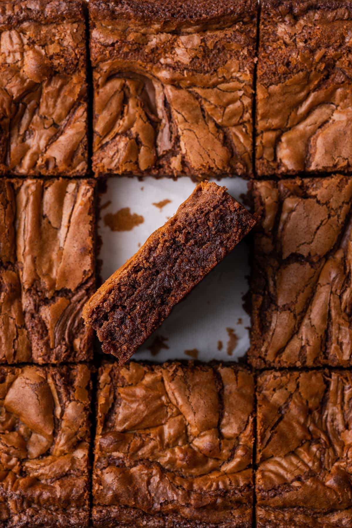 Overhead view of Nutella brownies cut into squares, with one brownie turned on its side.