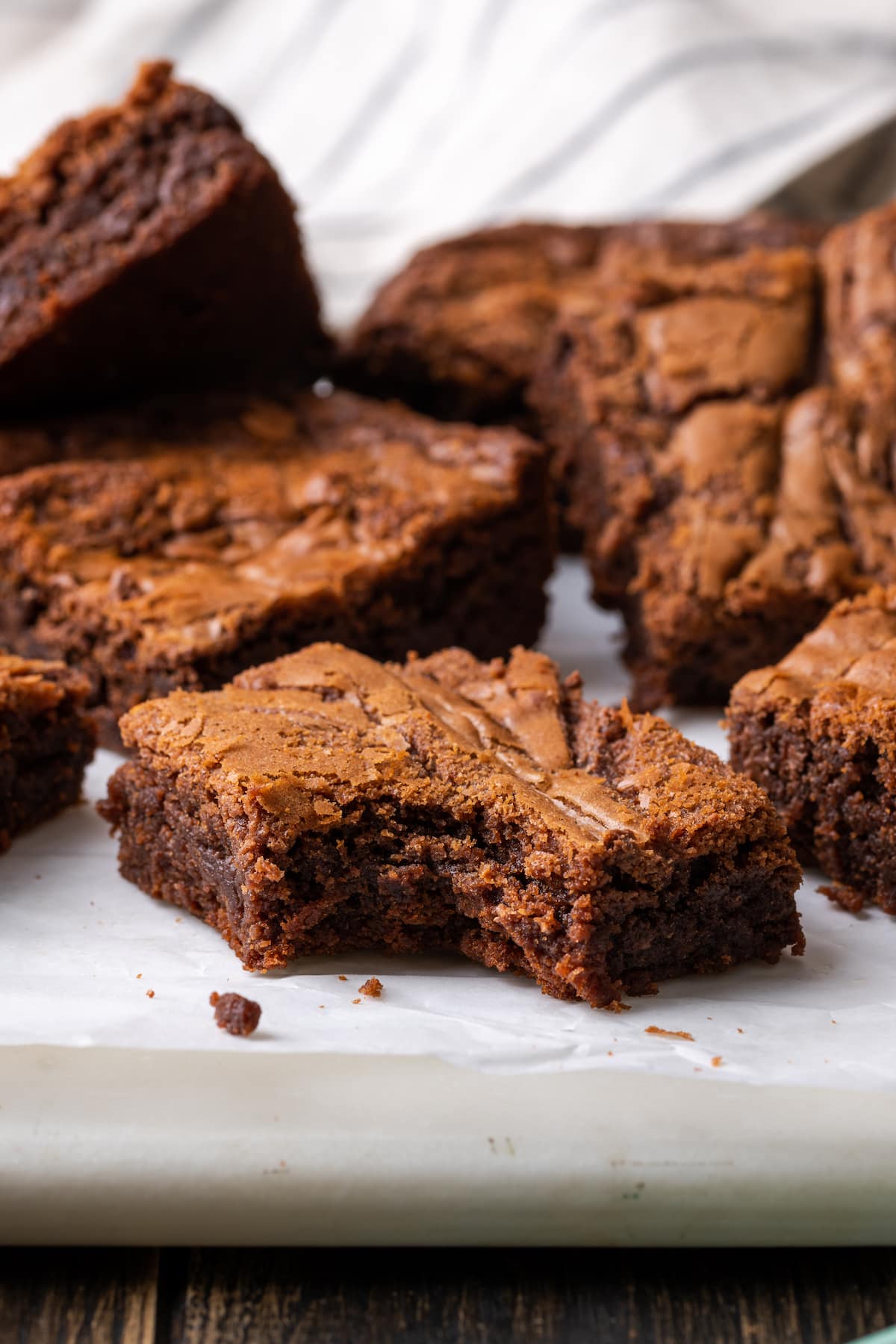 Nutella brownies on a cutting board with a bite missing from the front brownie.