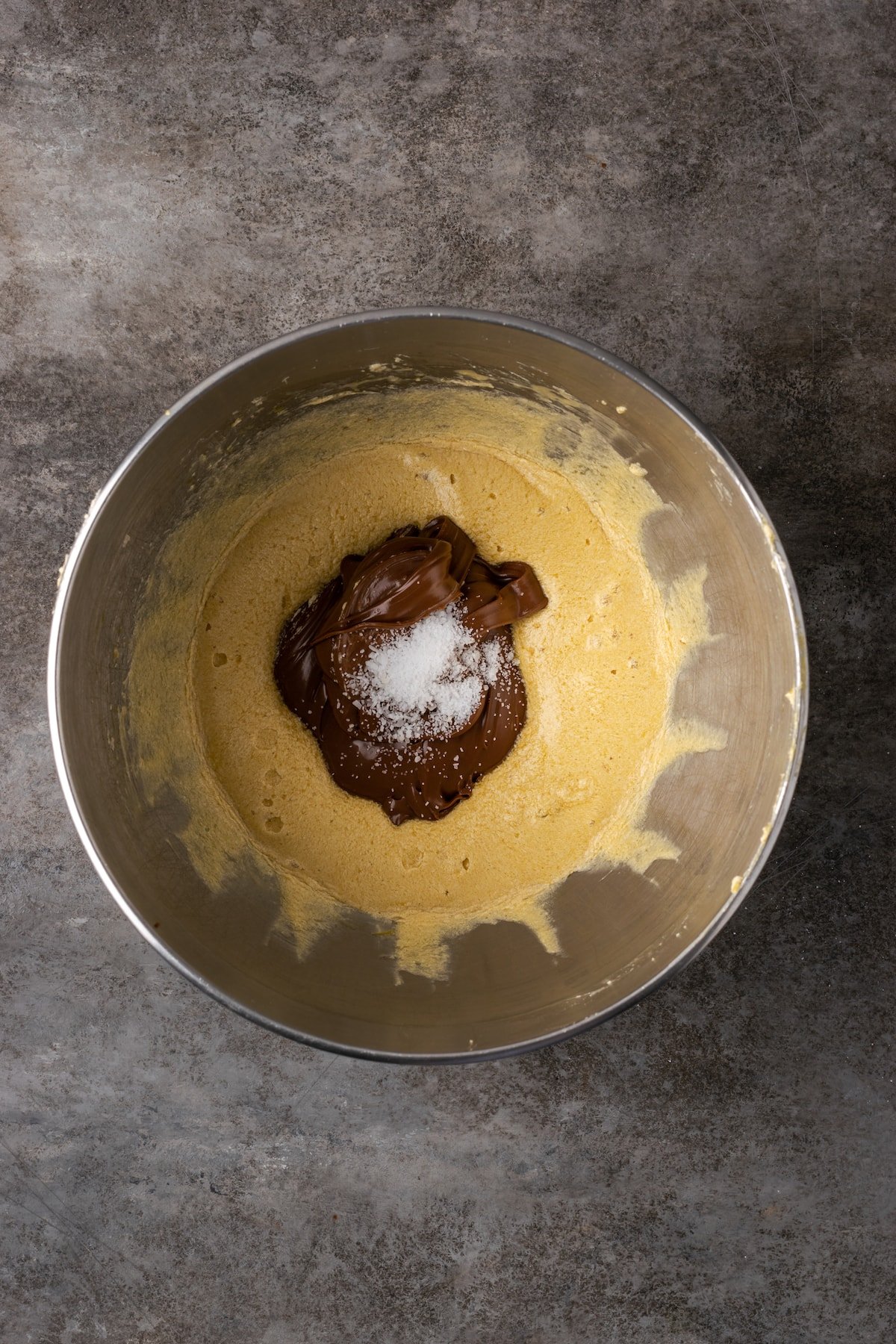 Nutella and salt added to the brownie ingredients in a mixing bowl.