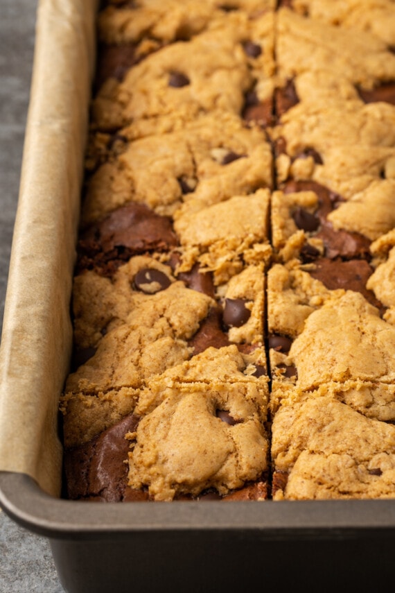 Close up of baked brookies in a parchment-lined baking pan.