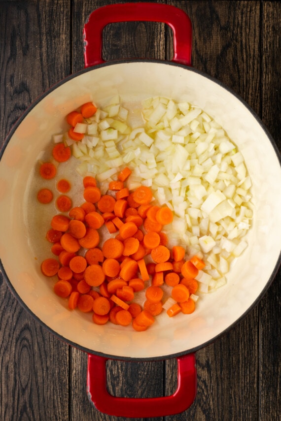Diced carrots and onion in the bottom of a large Dutch oven.