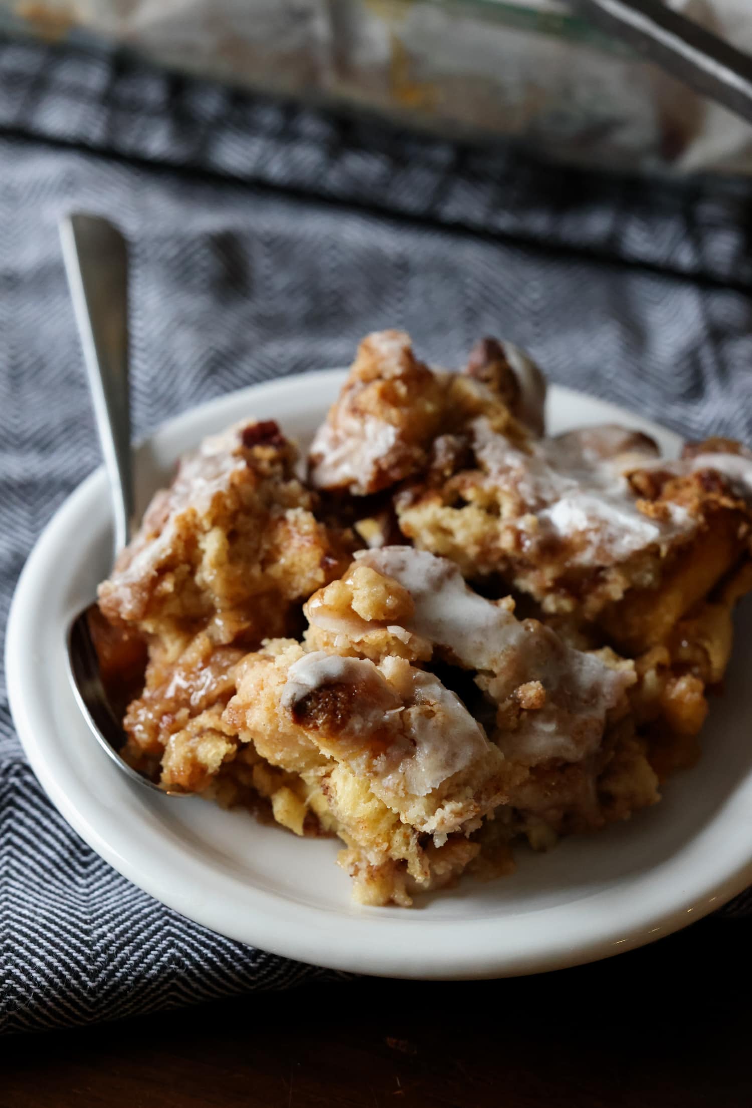A piece of cinnamon roll dump cake on a plate with a fork