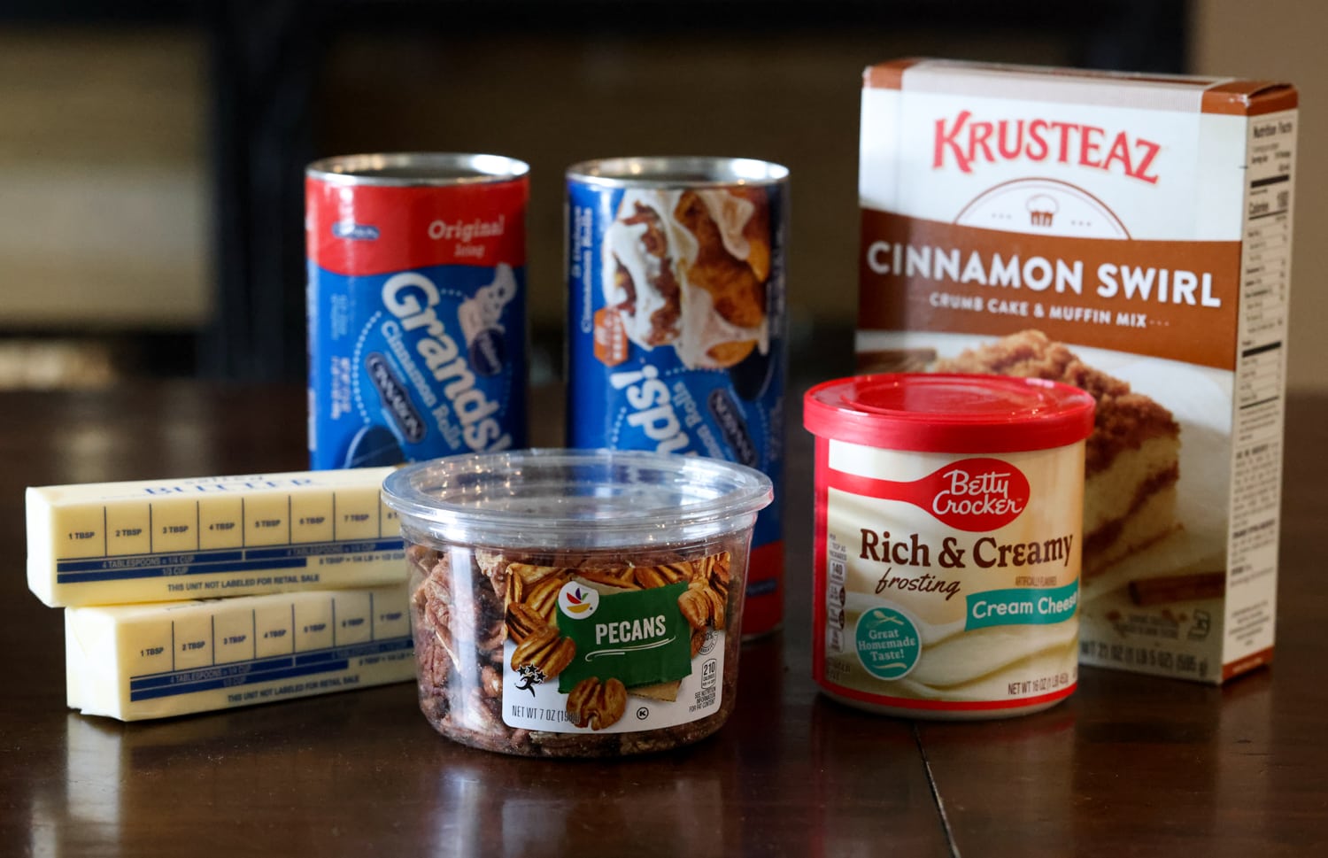 Ingredients for cinnamon roll dump cake: canned cinnamon rolls, frosting, butter, cake mix, pecans