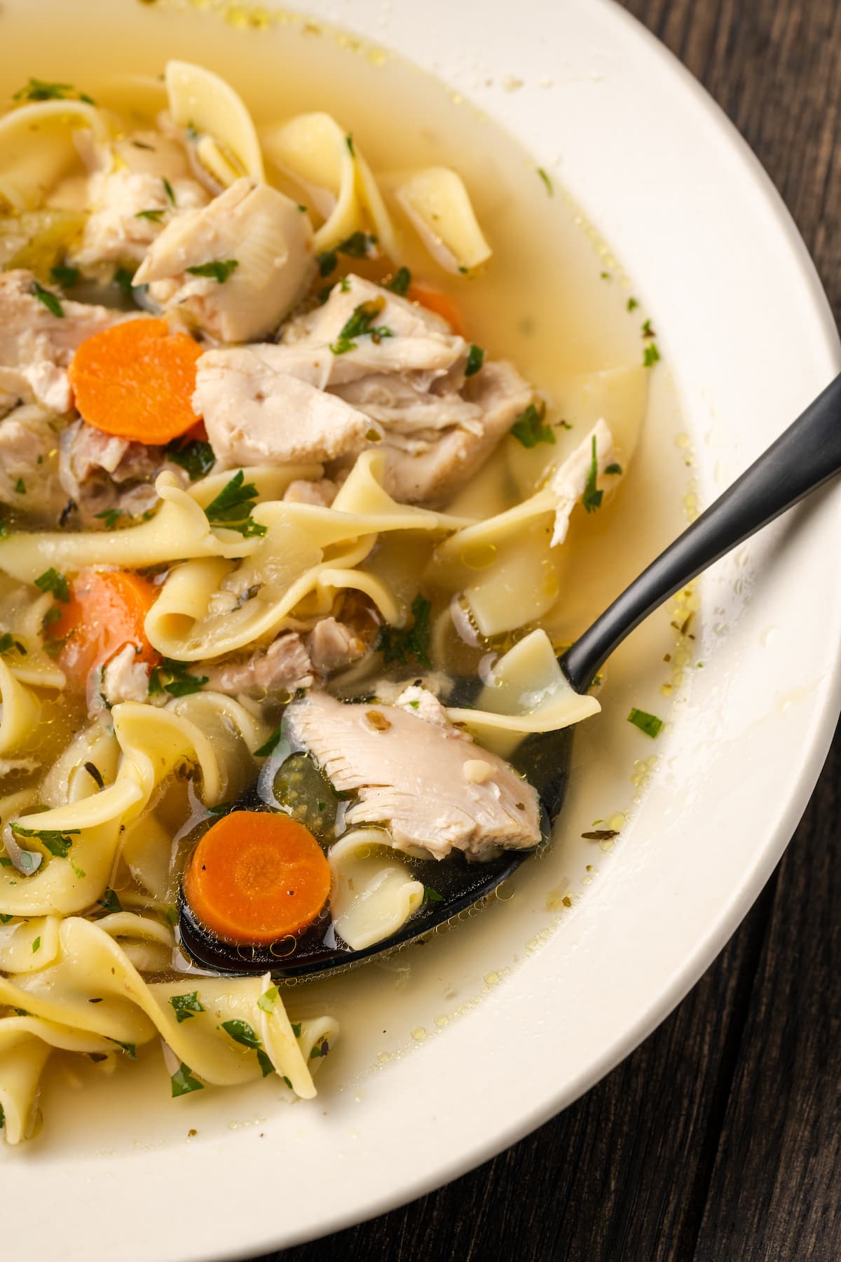 Overhead view of a bowl of Instant Pot chicken noodle soup with a spoon.