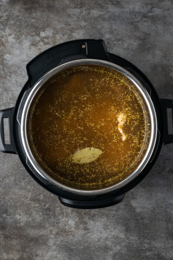 Chicken broth ingredients simmering inside the Instant Pot.