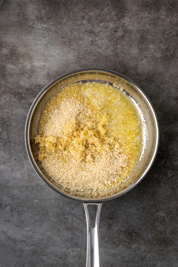 Breadcrumbs added to a saucepan with melted butter and garlic powder.
