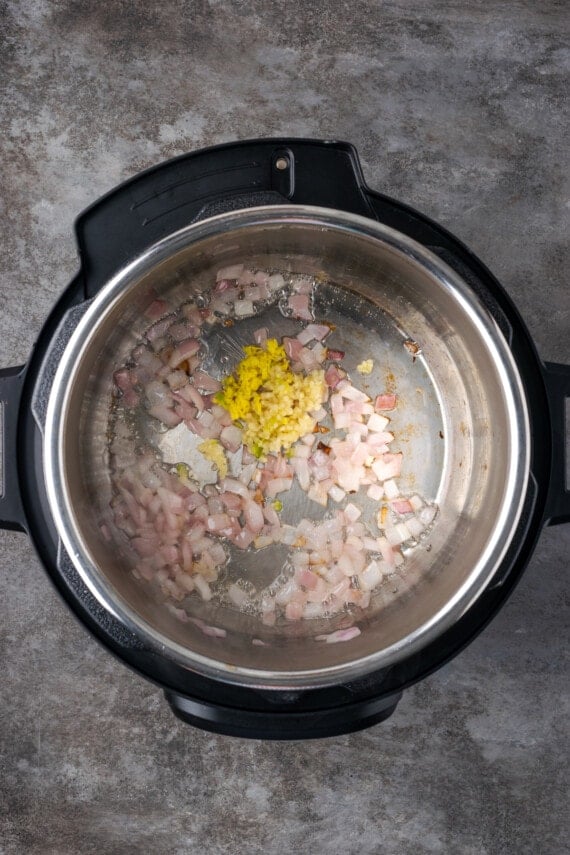 Diced onions and minced garlic sauteing inside the instant pot.