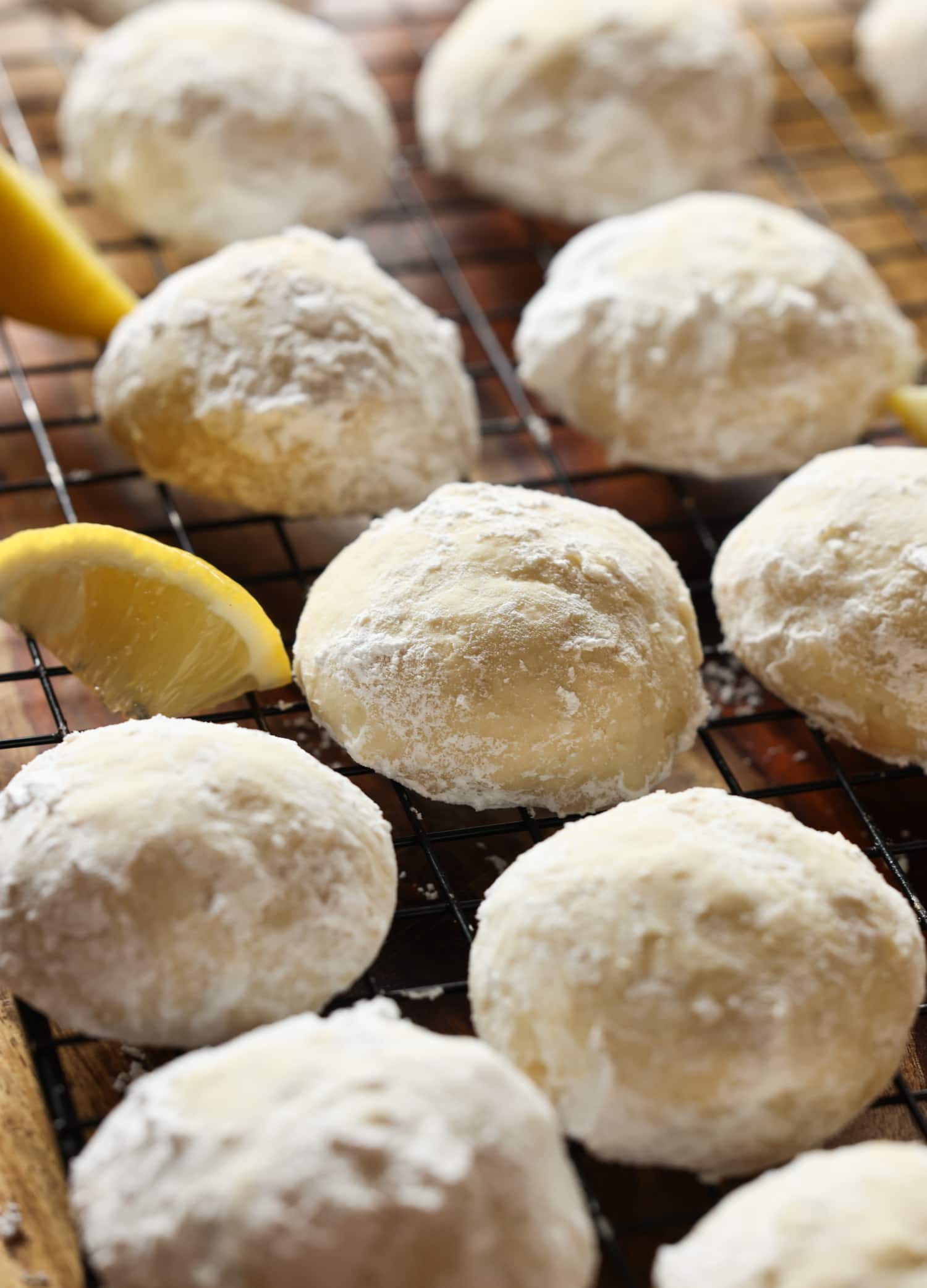 Lemon Cooler Cookies on a wire rack coated with powdered sugar