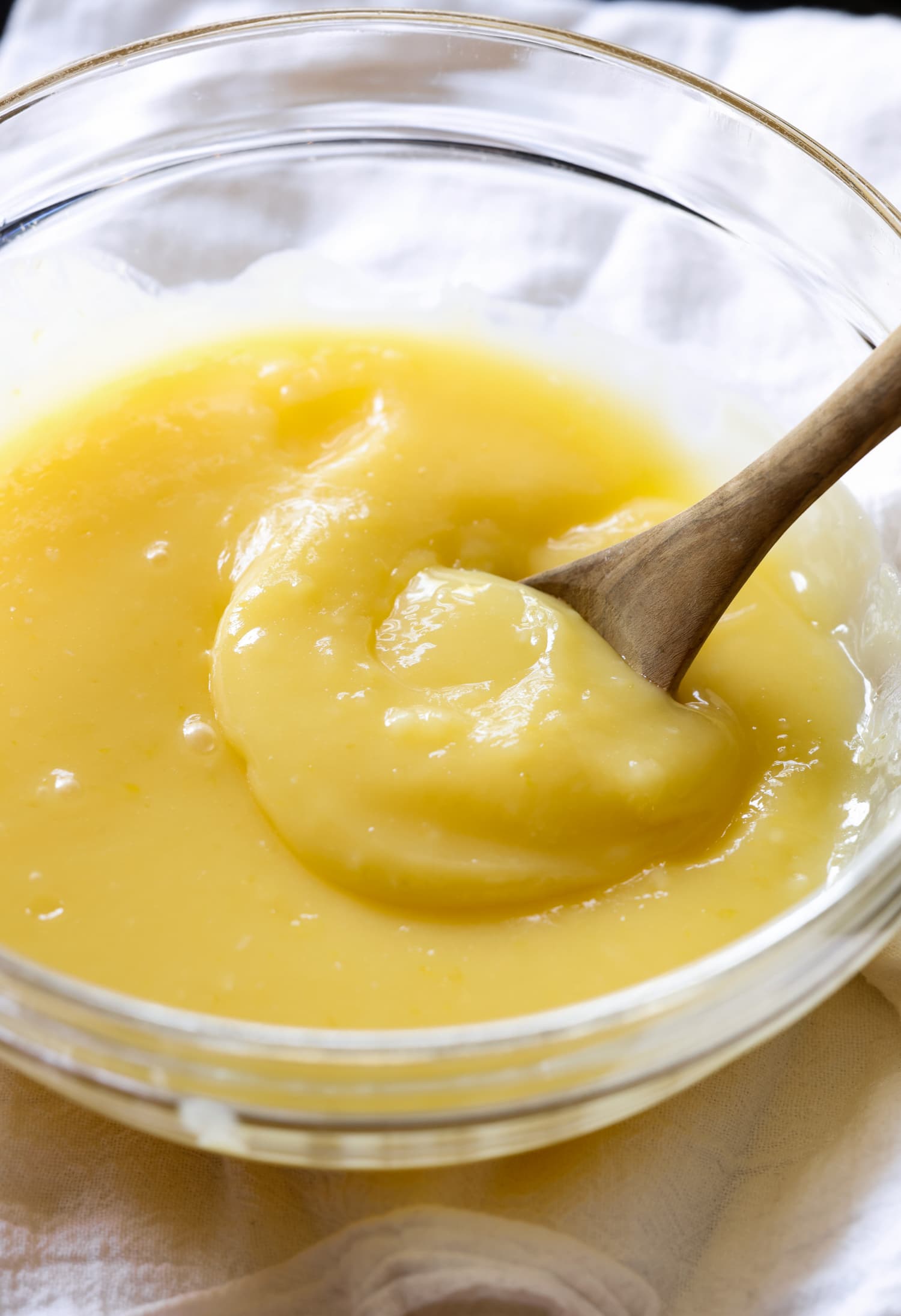 Warm homemade lemon curd in a bowl with a spoon