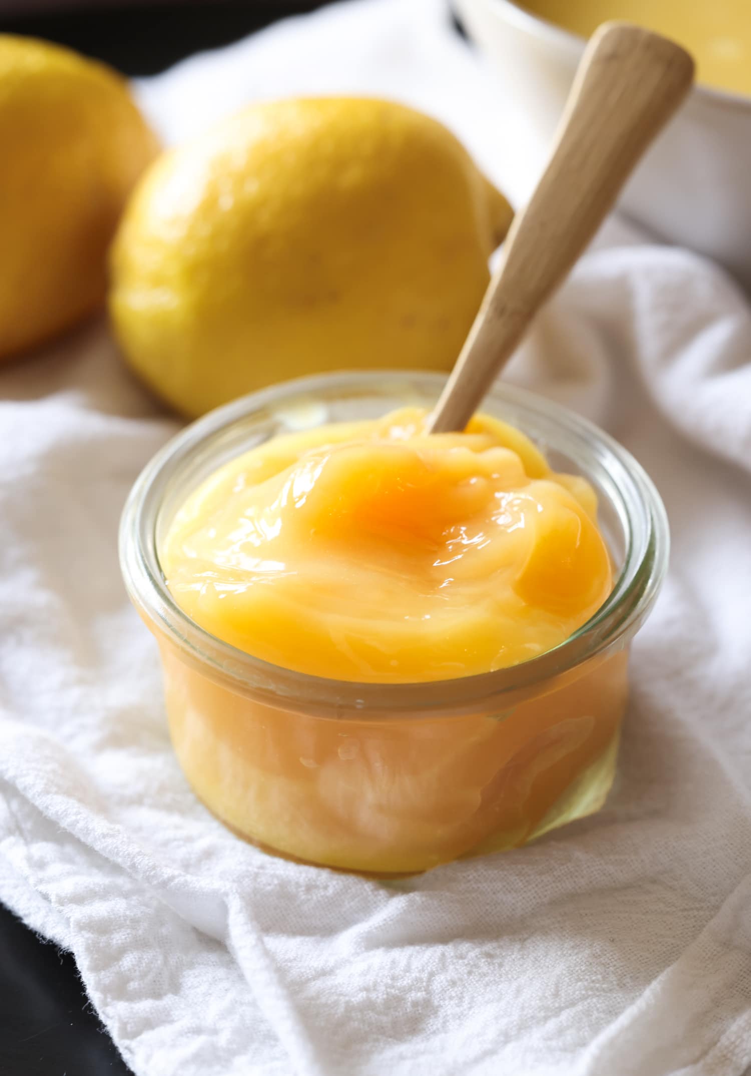 Lemon curd in a glass jar with a spoon