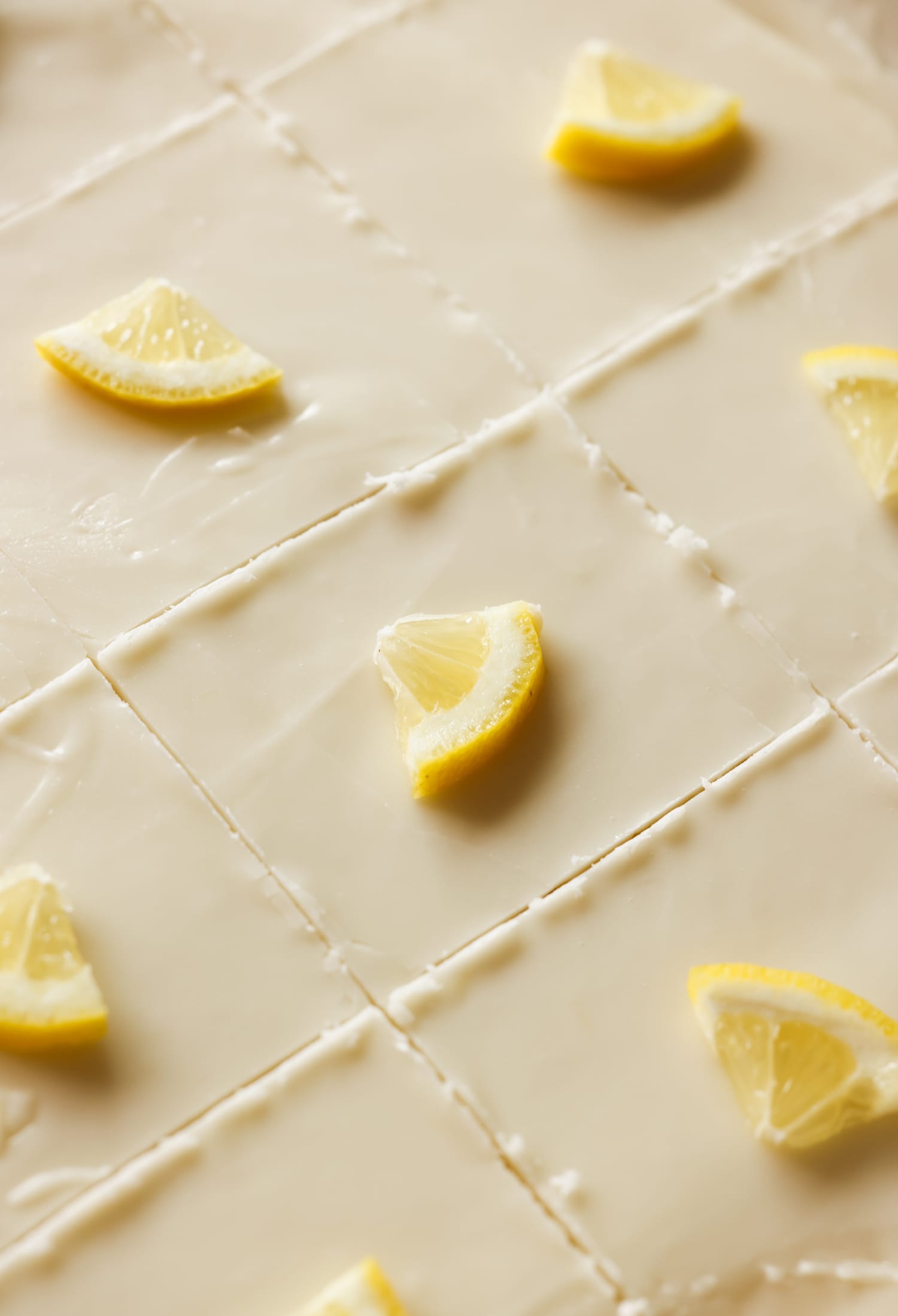 sheet cake in a pan sliced with lemon wedges