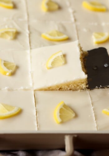 serving a slice of lemon sheet cake with a spatula