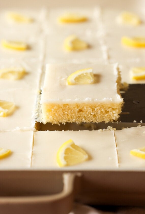 a slice of lemon sheet cake on a spatula showing the side view of the cake