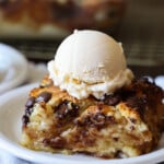 A piece of Biscuit Bread Pudding on a plate with ice cream