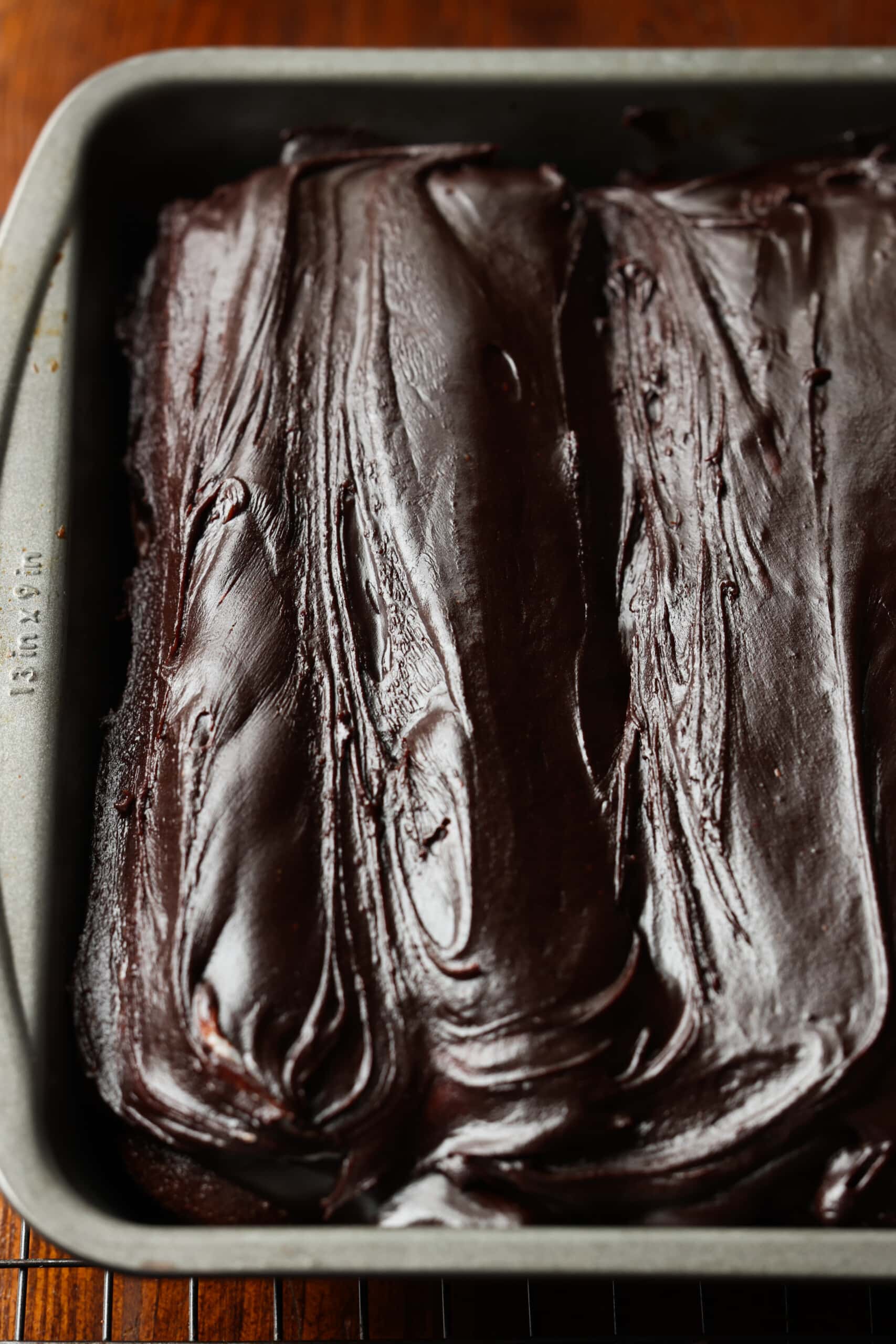 Pastel con glaseado de ganache de chocolate en una lata de 9x13