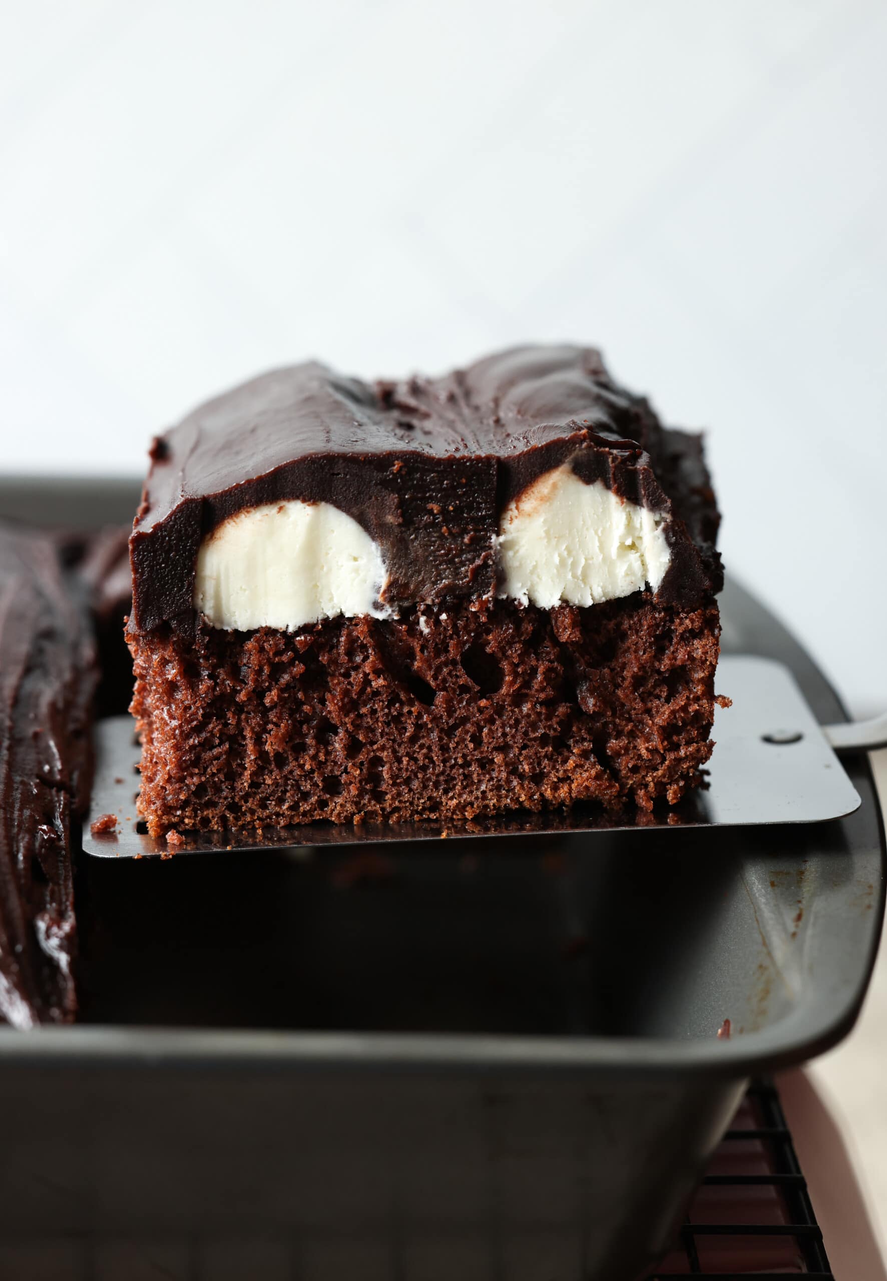 Bumpy Cake being serves on a spatula out of a 9x13