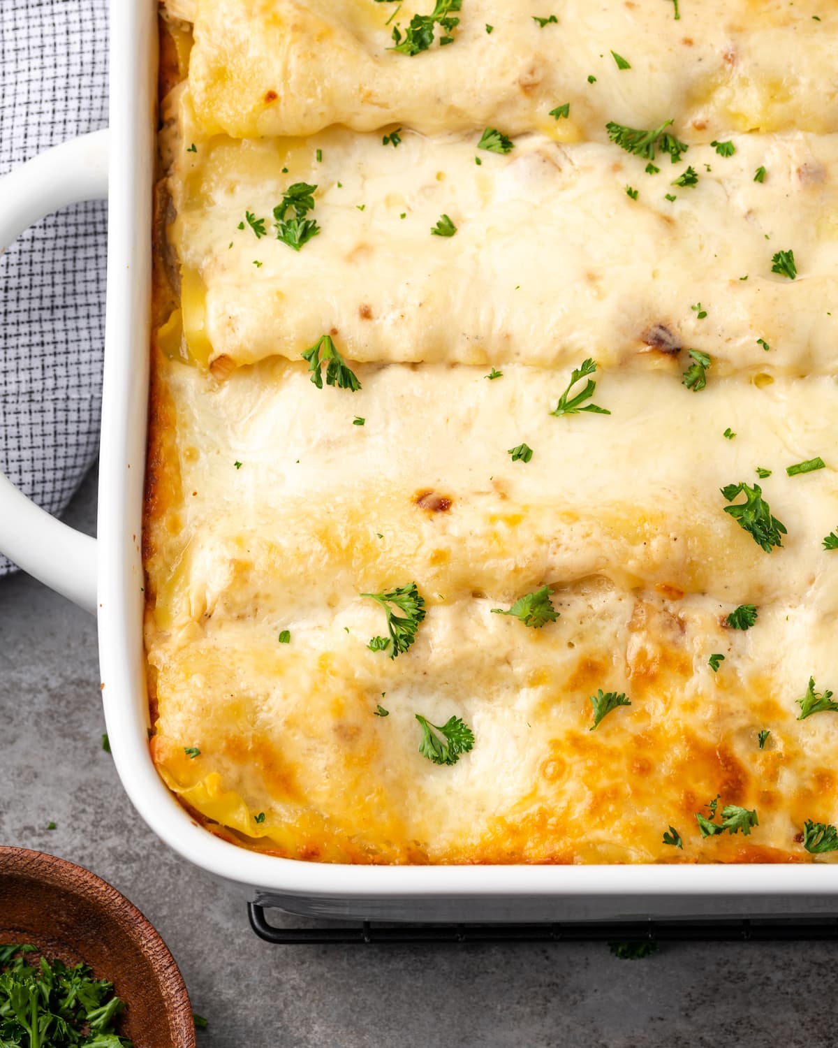 Close up of a corner of chicken lasagna in a casserole dish.