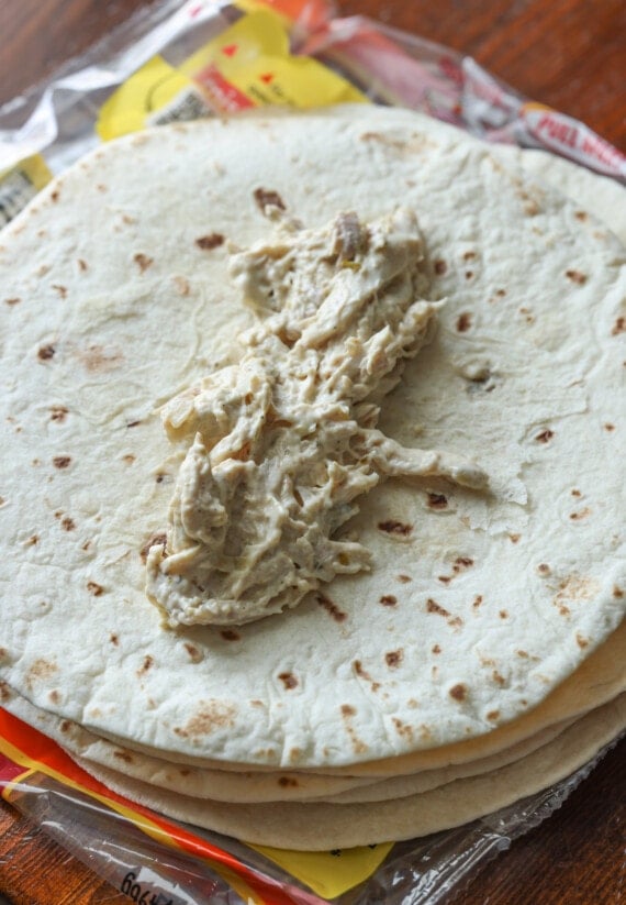 Place the creamy chicken mix on top of the flour tortilla before rolling